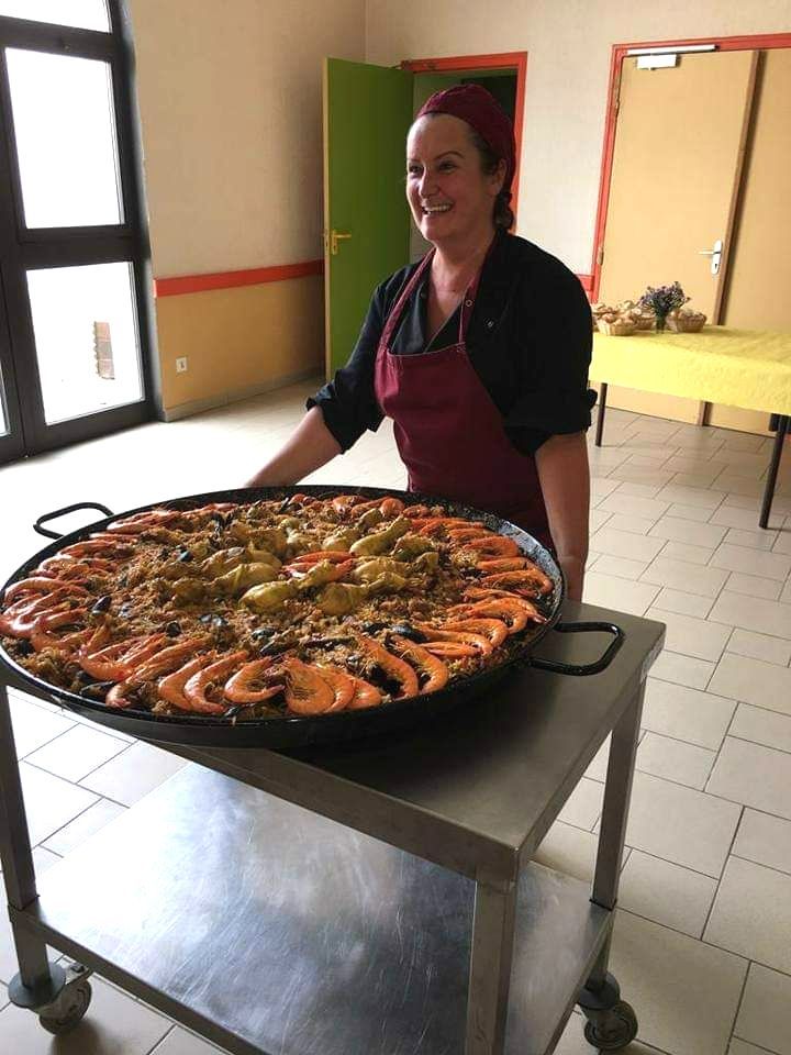 La cheffe avec une grande paella