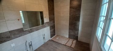 Salle de bains en rénovation avec murs carrelés, niche pour meuble lavabo et fenêtre sur la droite. Caen Salle de bains en rénovation avec murs carrelés, niche pour meuble lavabo et fenêtre sur la droite