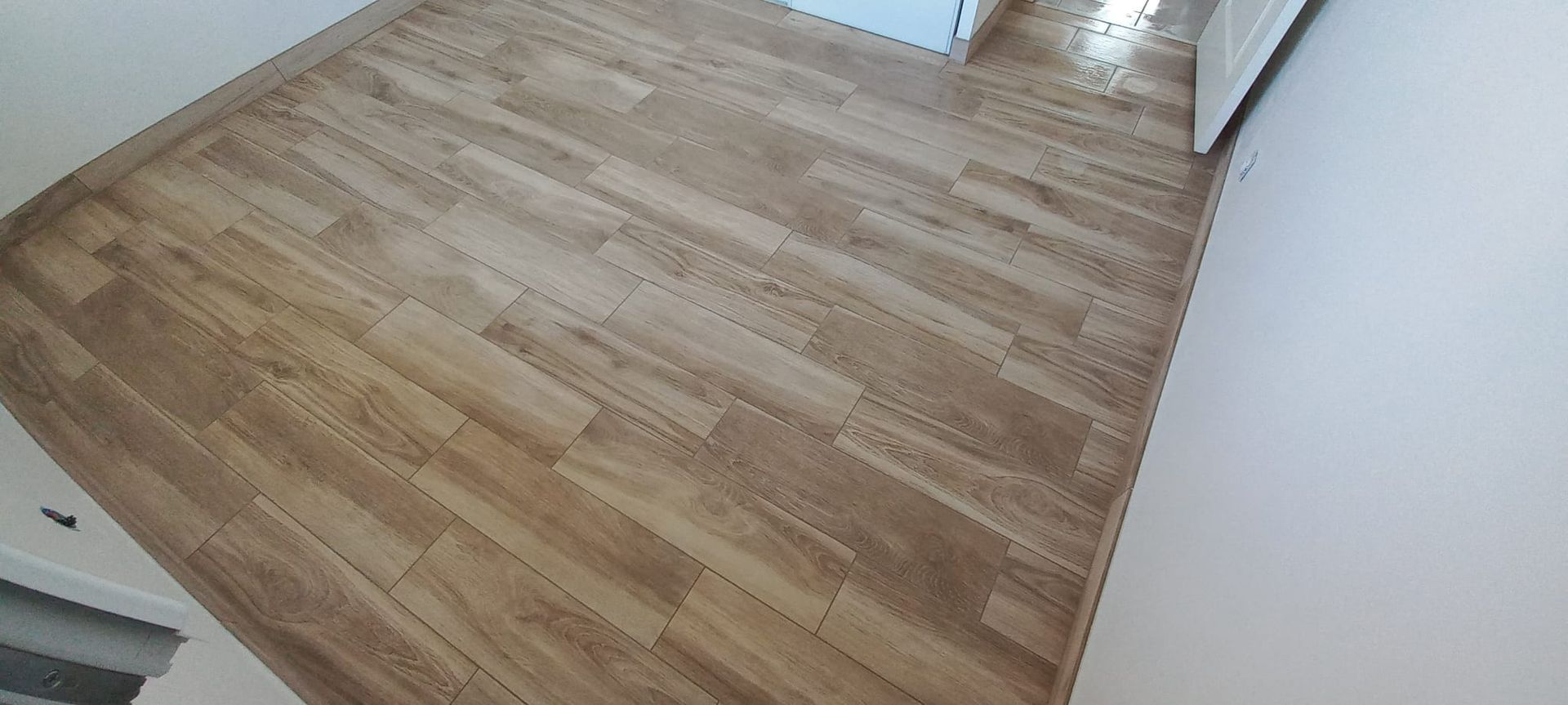 Parquet clair nu dans un coin de pièce lumineuse aux murs blancs et à la fenêtre