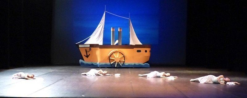 Danseuses au sol et décor avec un bateau