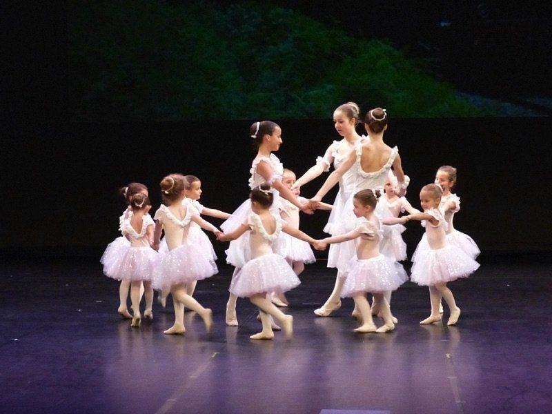 Nombreuses danseuses enfants entourant danseuses adultes