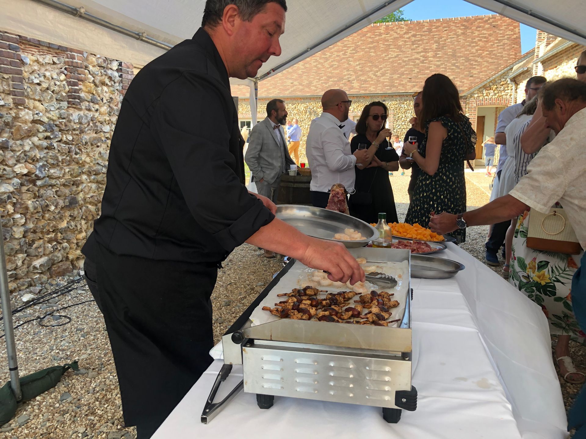 Un chef traiteur cuisinant sur une plancha électrique duirant un évènement privé