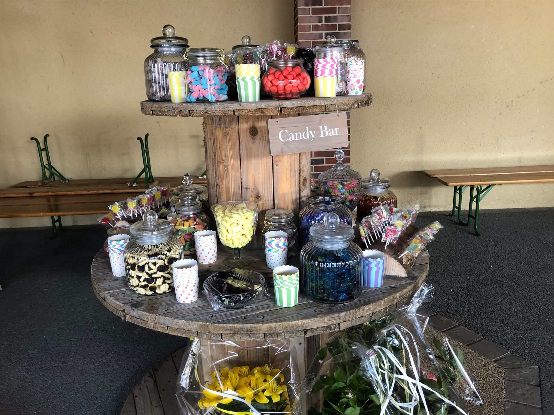 Buffet sucrés sur présentoir en bois avec pancarte ayant pour mention Candy Bar