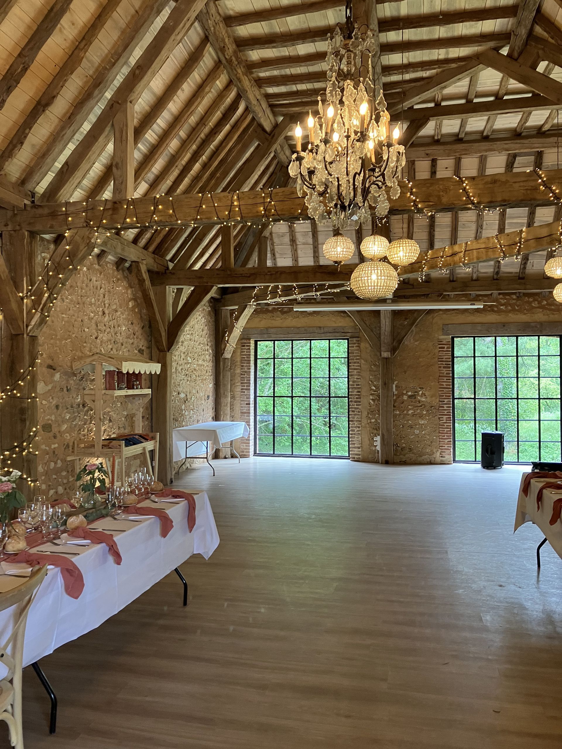 Reception avec buffet avec baie vitrée en arrière plan et guirlandes lumineuses