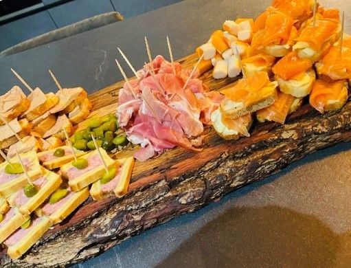 Un cuisinier plaçant un morceau de pain dans un plateaux repas garnit