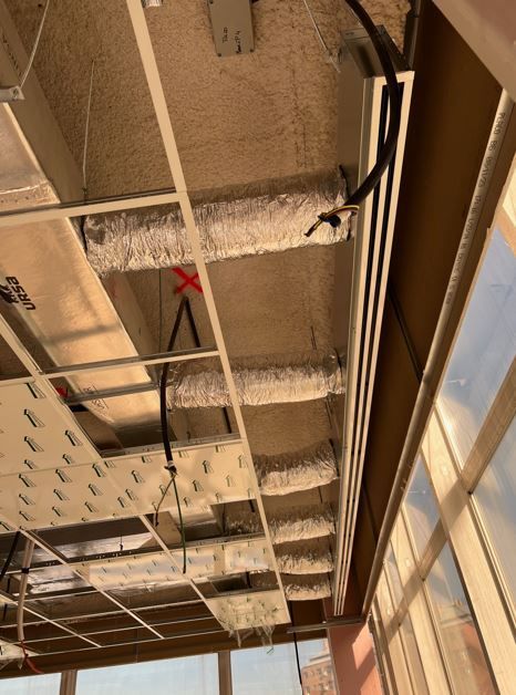 Techo de obra con conductos, cableado eléctrico y estructura de metal.