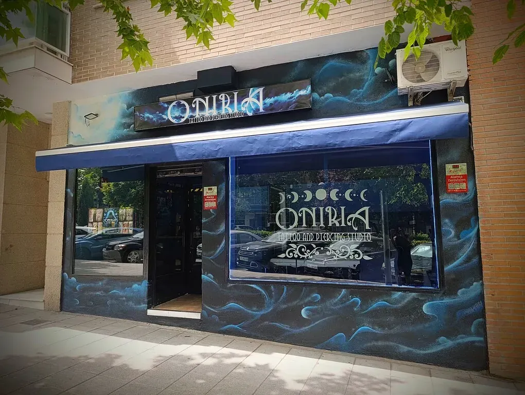 Una fachada de tienda con un toldo azul y grafitis.