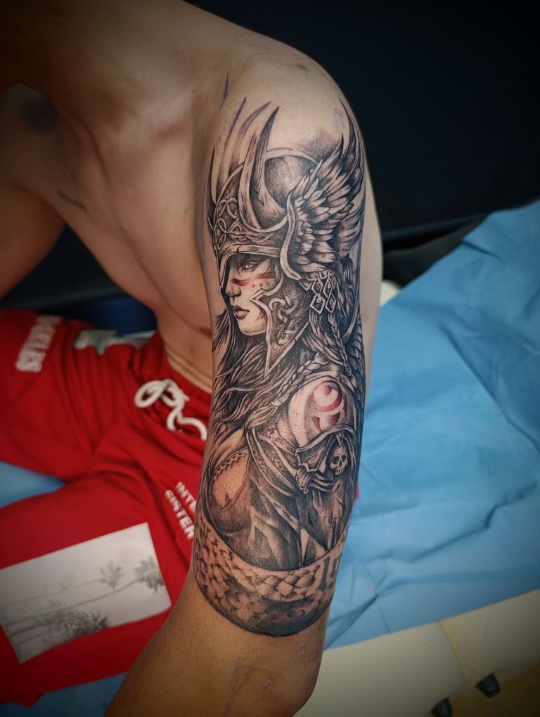Un hombre tiene un tatuaje de una mujer con cuernos en su brazo.