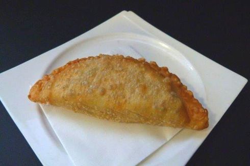 Un pastel frito en un plato blanco con una servilleta