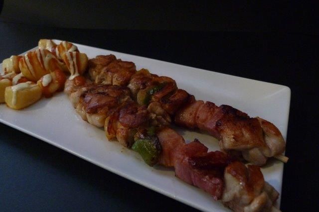 Un plato blanco cubierto con carne y papas fritas.