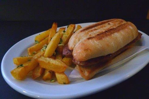 Un sándwich y papas fritas en un plato blanco