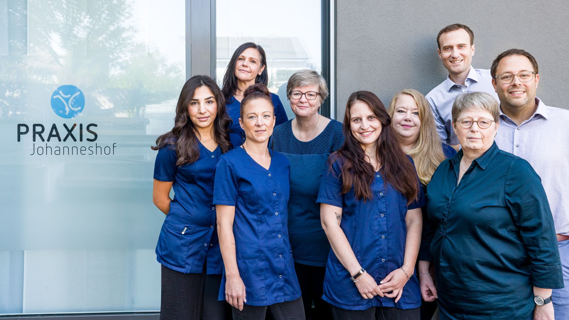 Eine Gruppe von Menschen in blauen Kitteln posiert für ein Foto.