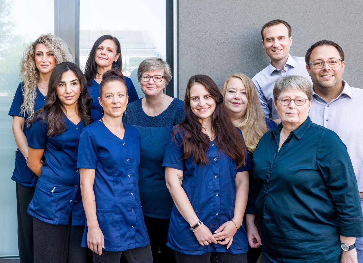Eine Gruppe von Menschen in blauen Kitteln posiert für ein Foto.