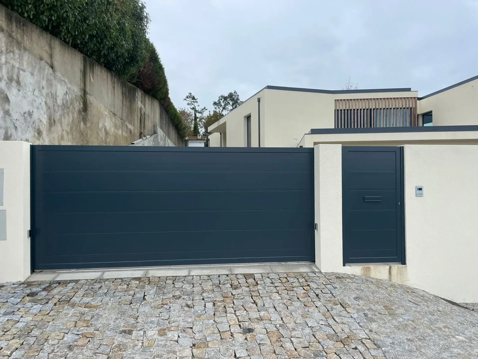 There is a sliding gate in front of a house.