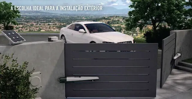 A white car is parked in front of a black gate