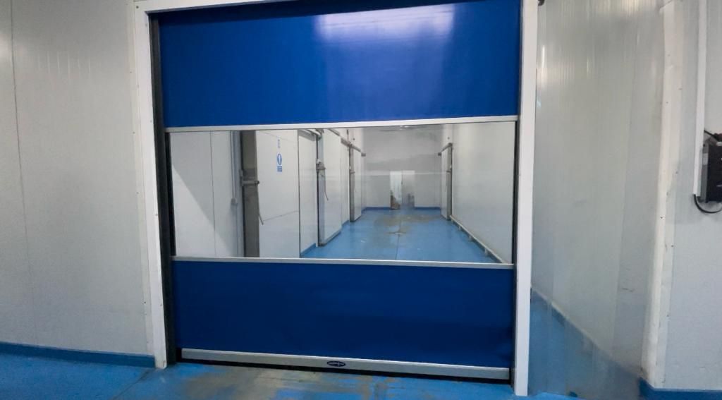 There is a blue door in the middle of a hallway.