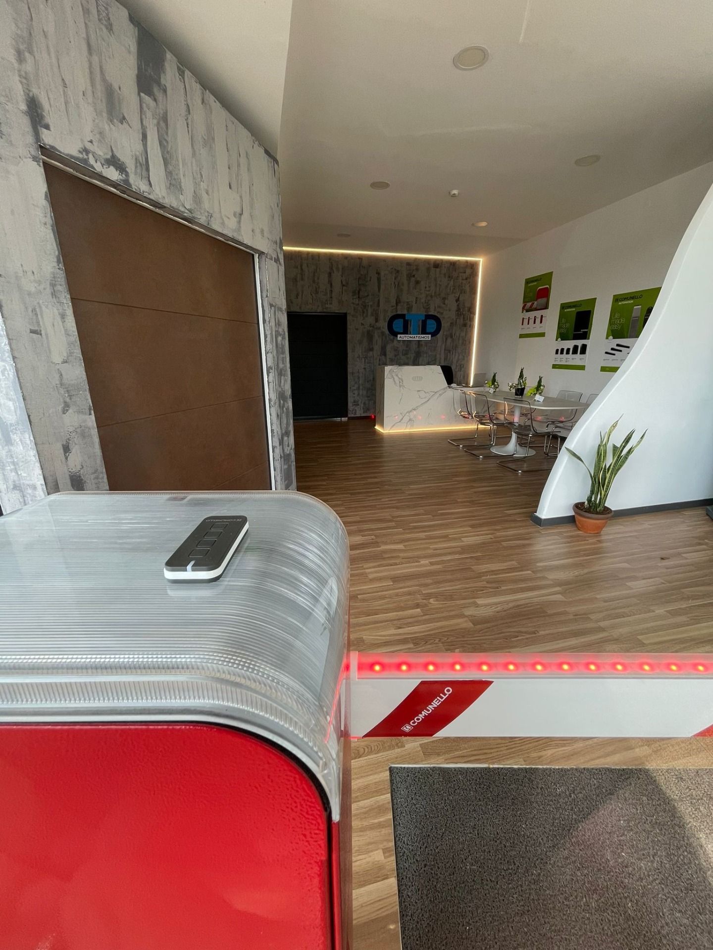 A cell phone is sitting on top of a red suitcase in a room.