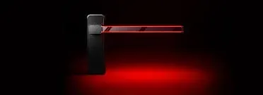 A red light is shining on a black object in a dark room.