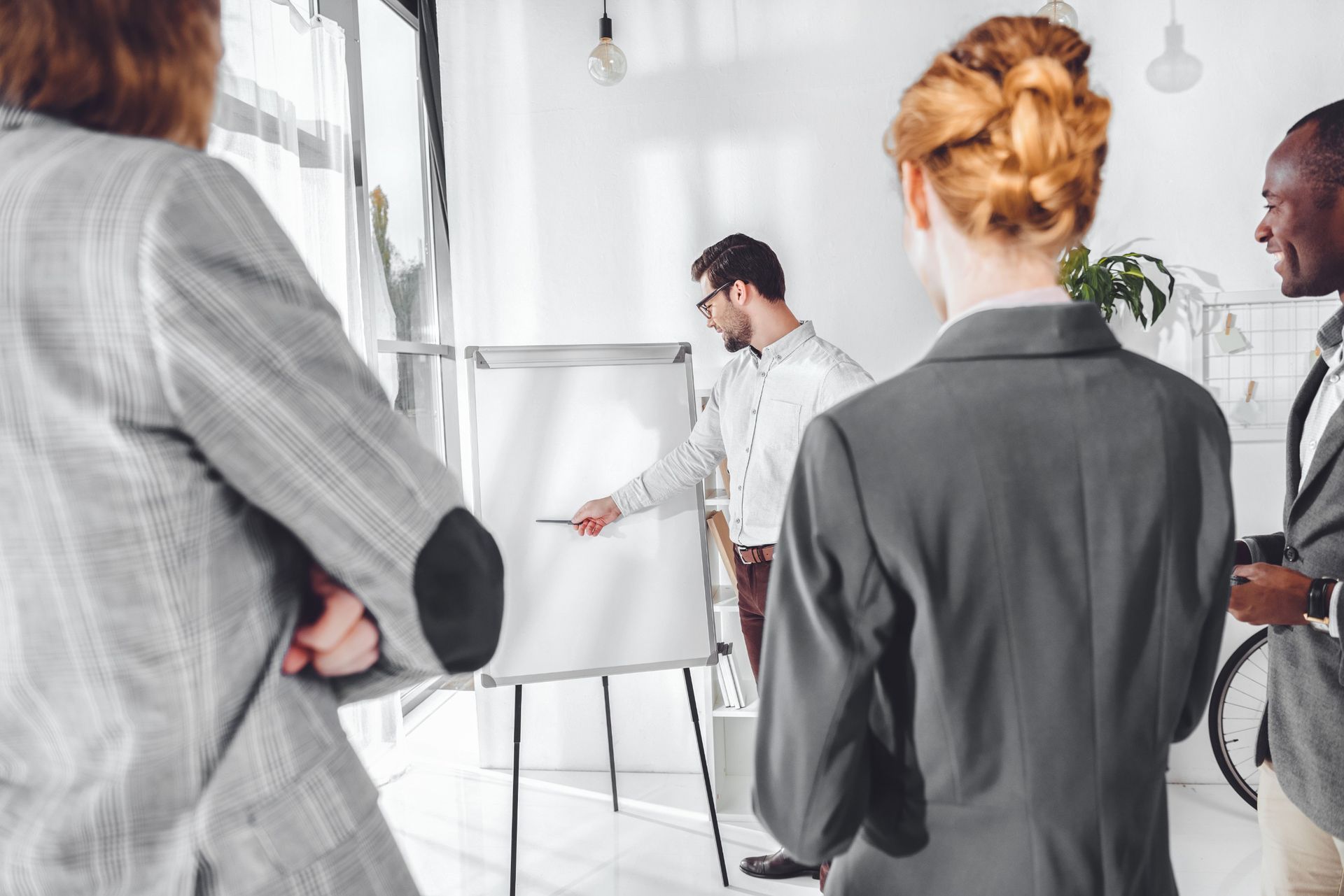 Un hombre está dando una presentación a un grupo de gente de negocios.