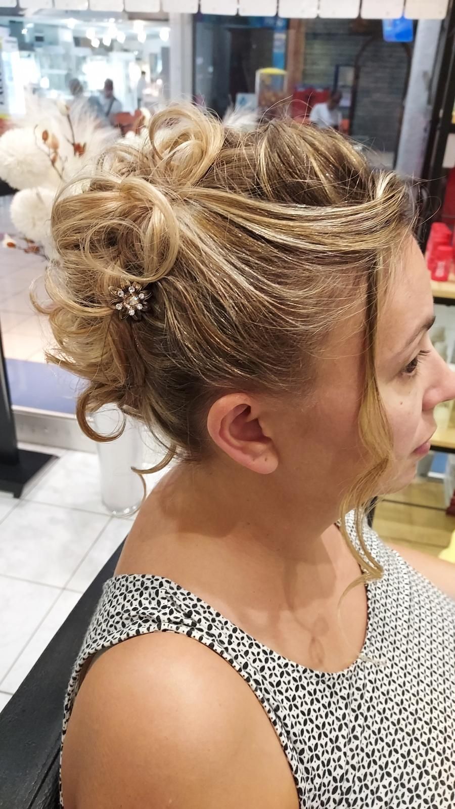Vue de profil d'une femme blonde aux cheveux relevés, portant un débardeur à motifs à l'intérieur.