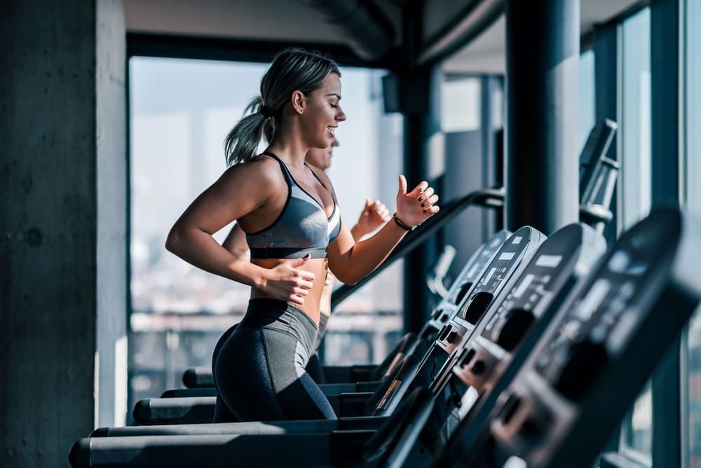 Eine Frau läuft auf einem Laufband in einem Fitnessstudio | bodyfit24