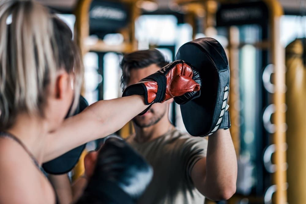 Ein Mann und eine Frau trainieren Boxen in einem Fitnessstudio | bodyfit24