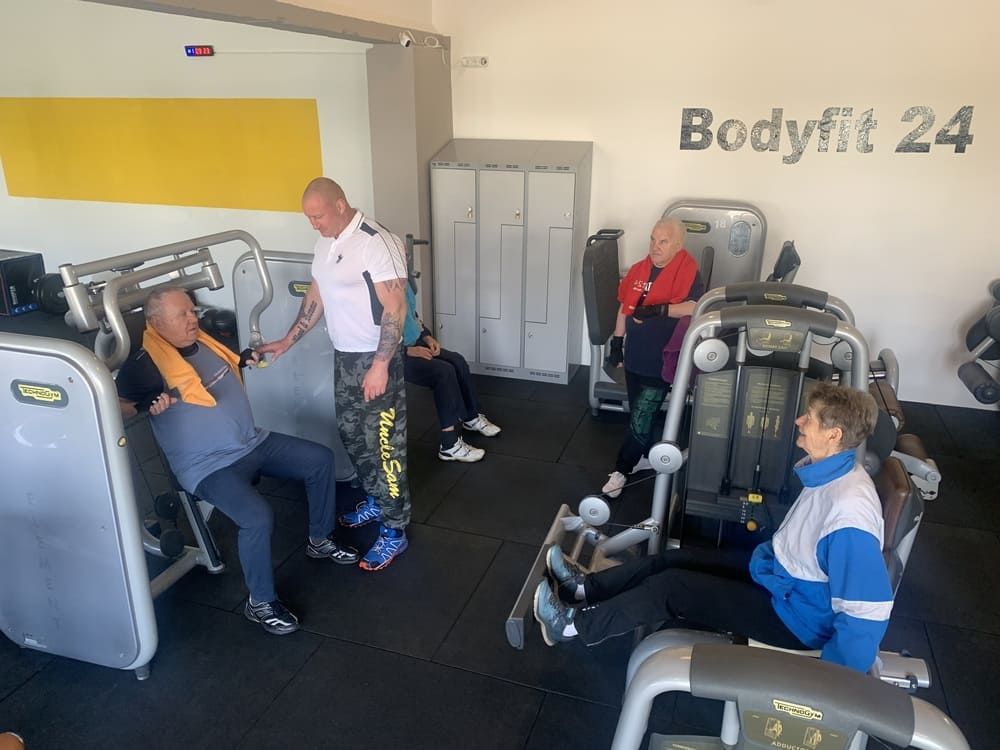 Eine Gruppe von Menschen, die in einem Fitnessstudio trainieren | bodyfit24