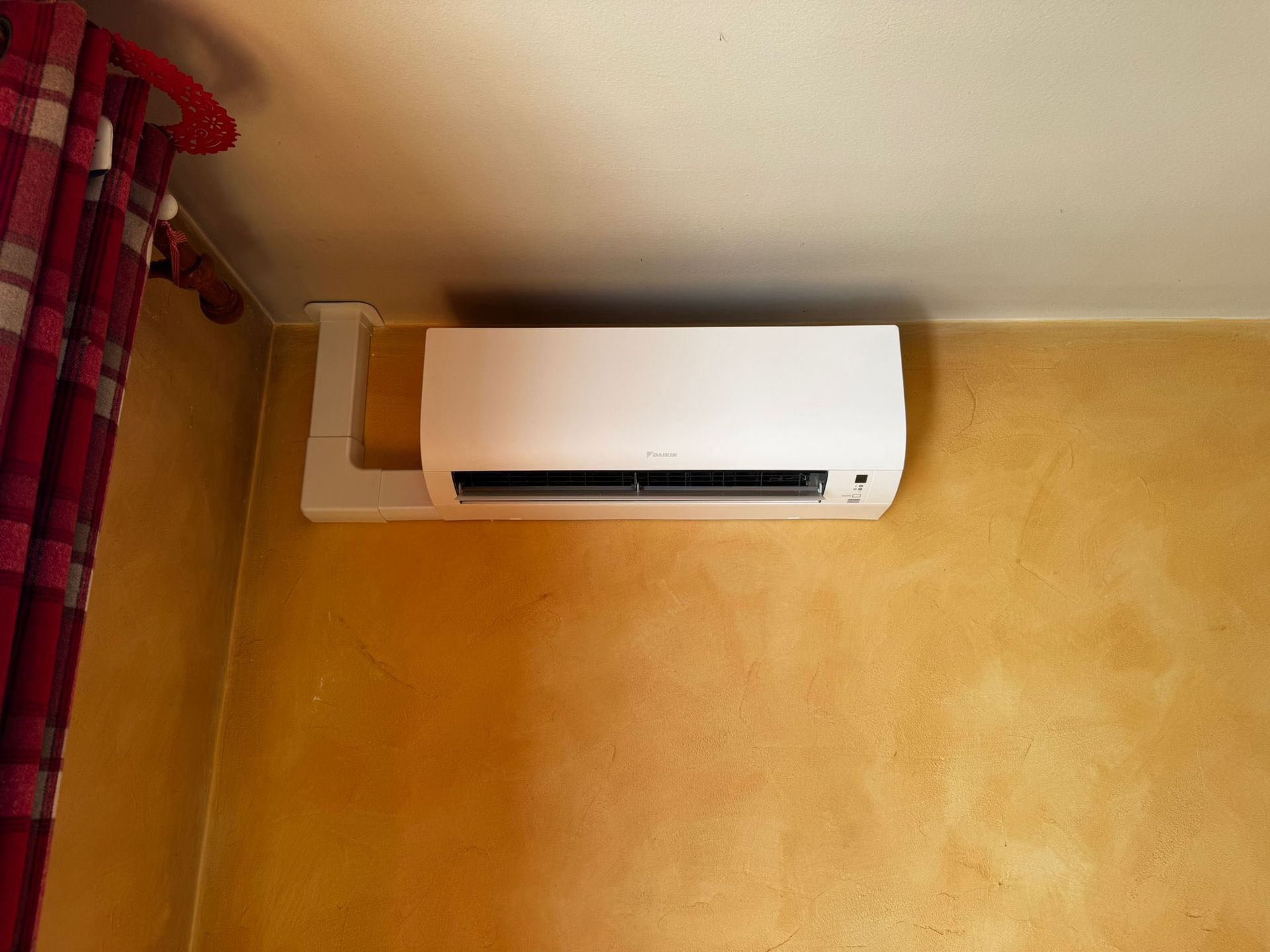 Un climatiseur intérieur sur mur orange