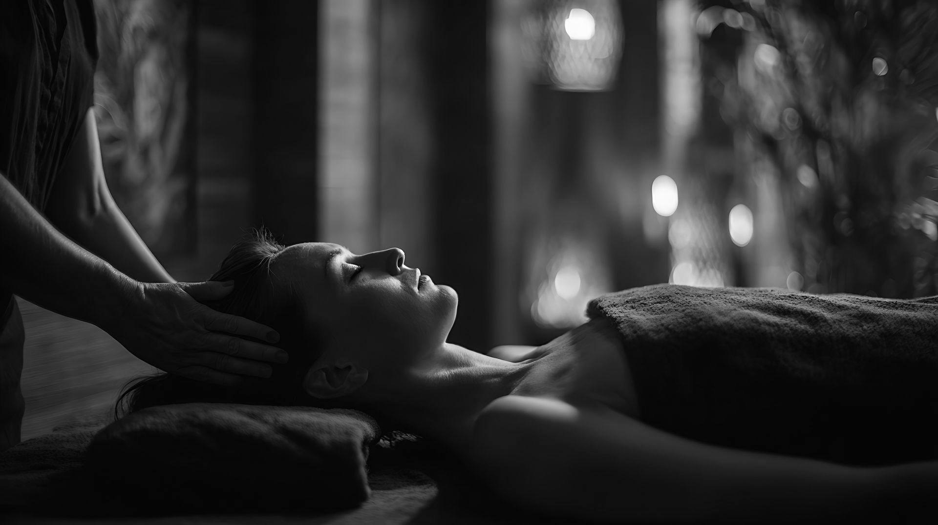 Une femme ferme les yeux couverte par une serviette.