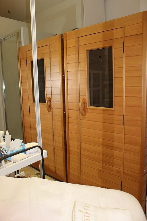 Portes en bois d'un sauna ou d'un hammam à côté d'un lit d'hôpital dans une chambre clinique