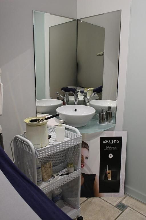 Poste de lavage de salon avec miroirs, lavabos, serviettes et produits capillaires sur chariot