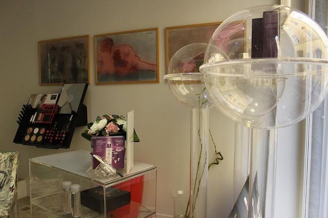 Un arrangement de ballons à côté d'œuvres d'art encadrées et d'une table avec des fleurs dans une pièce lumineuse