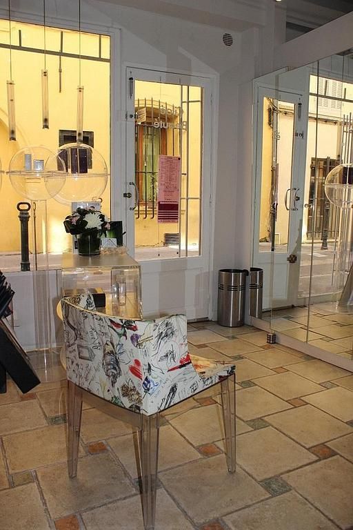 Hall d'entrée lumineux avec portes vitrées et pouf décoratif sur un sol carrelé