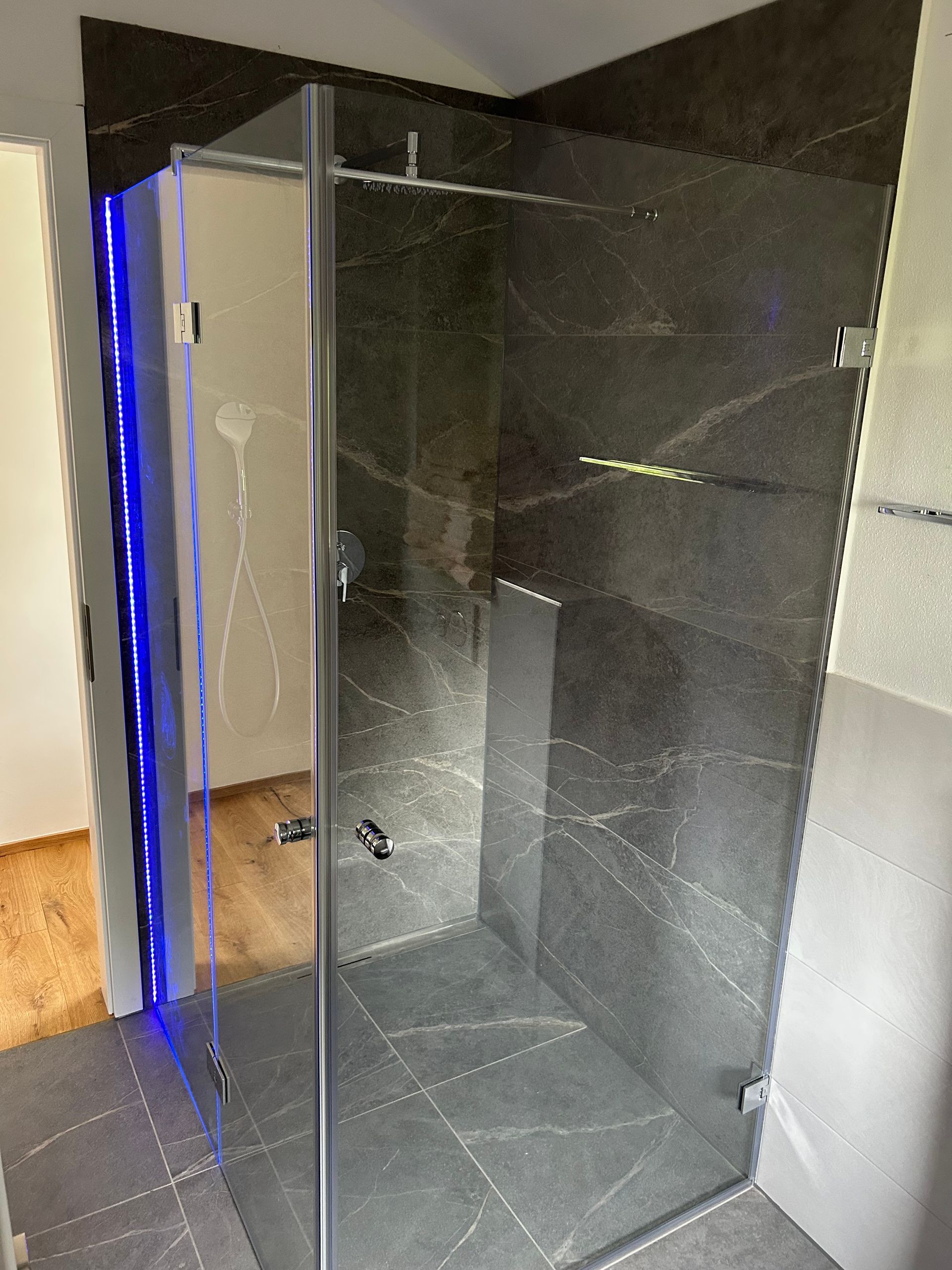 Rahmenlose Glasdusche mit Klarglas und Schwingtür.