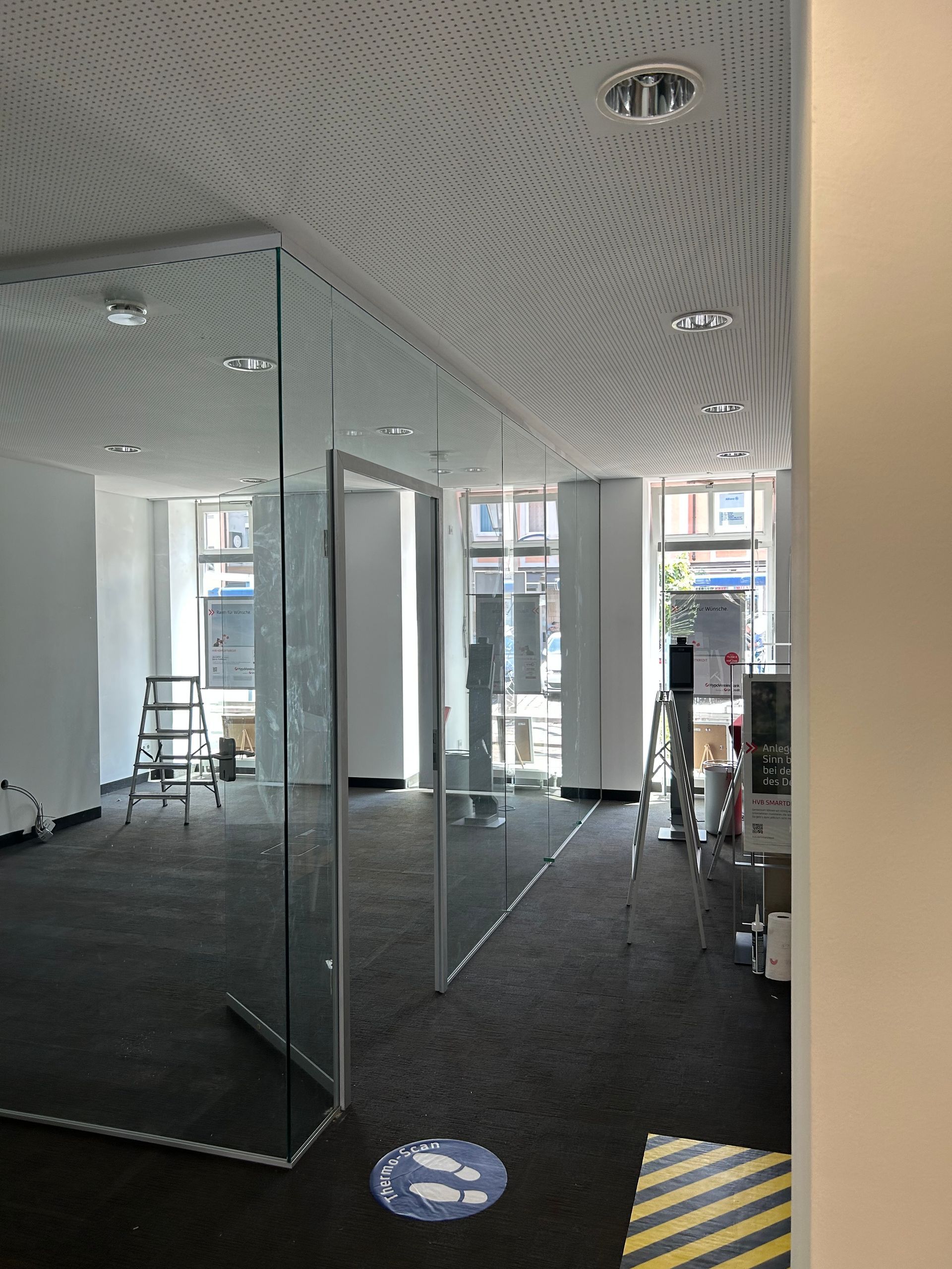 Moderne Bürotrennwand aus klarem Glas mit Aluminiumrahmen für offene Büros.