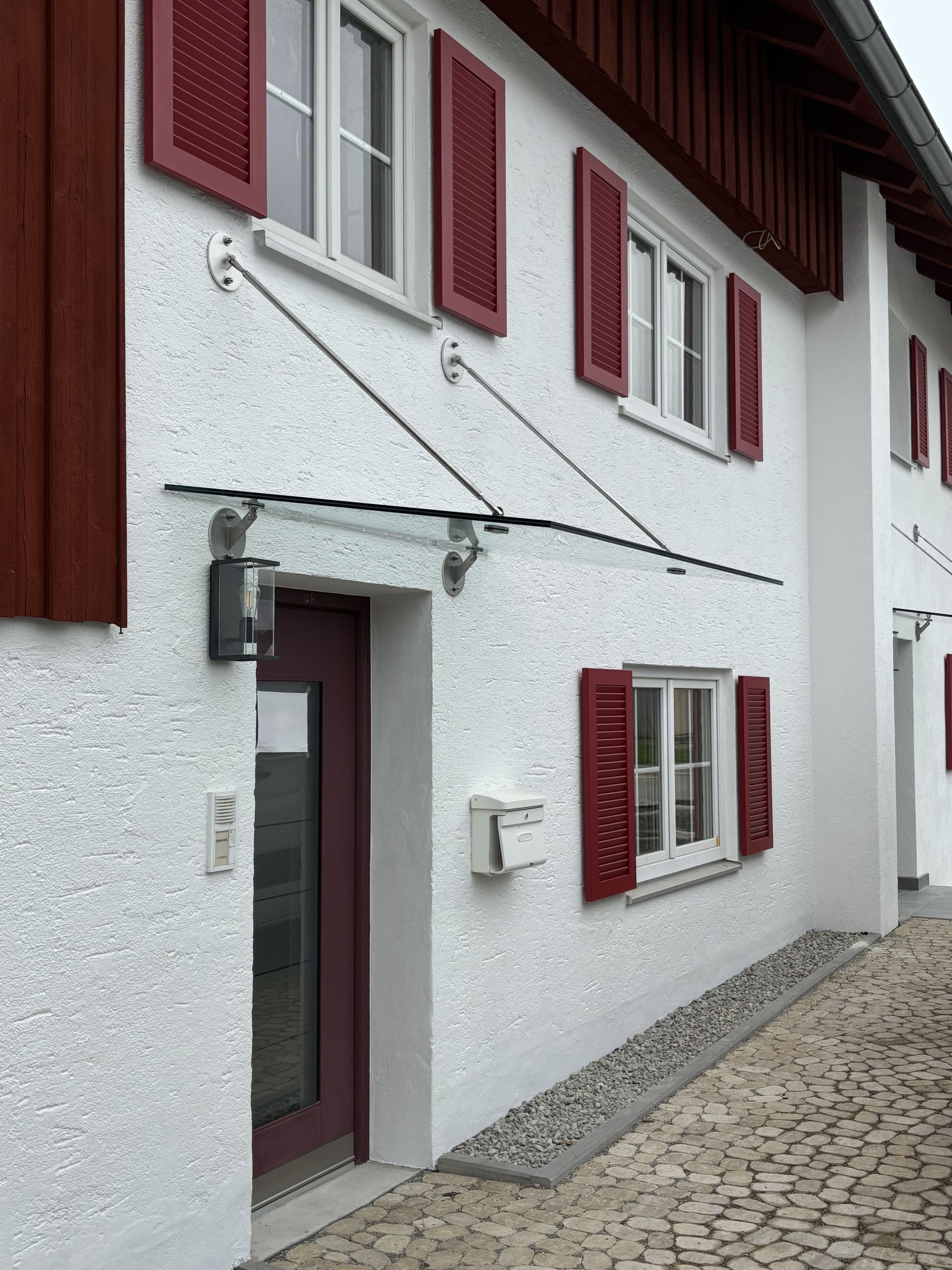 Schwebendes Glasvordach mit punktgehaltenem System an der Fassade.