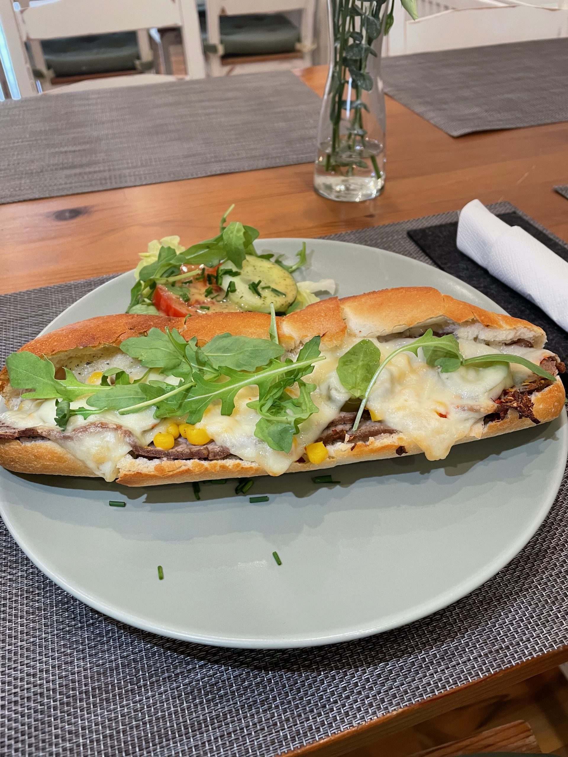 Ein Teller mit Essen und einem Sandwich darauf auf einem Tisch, Mom & Son