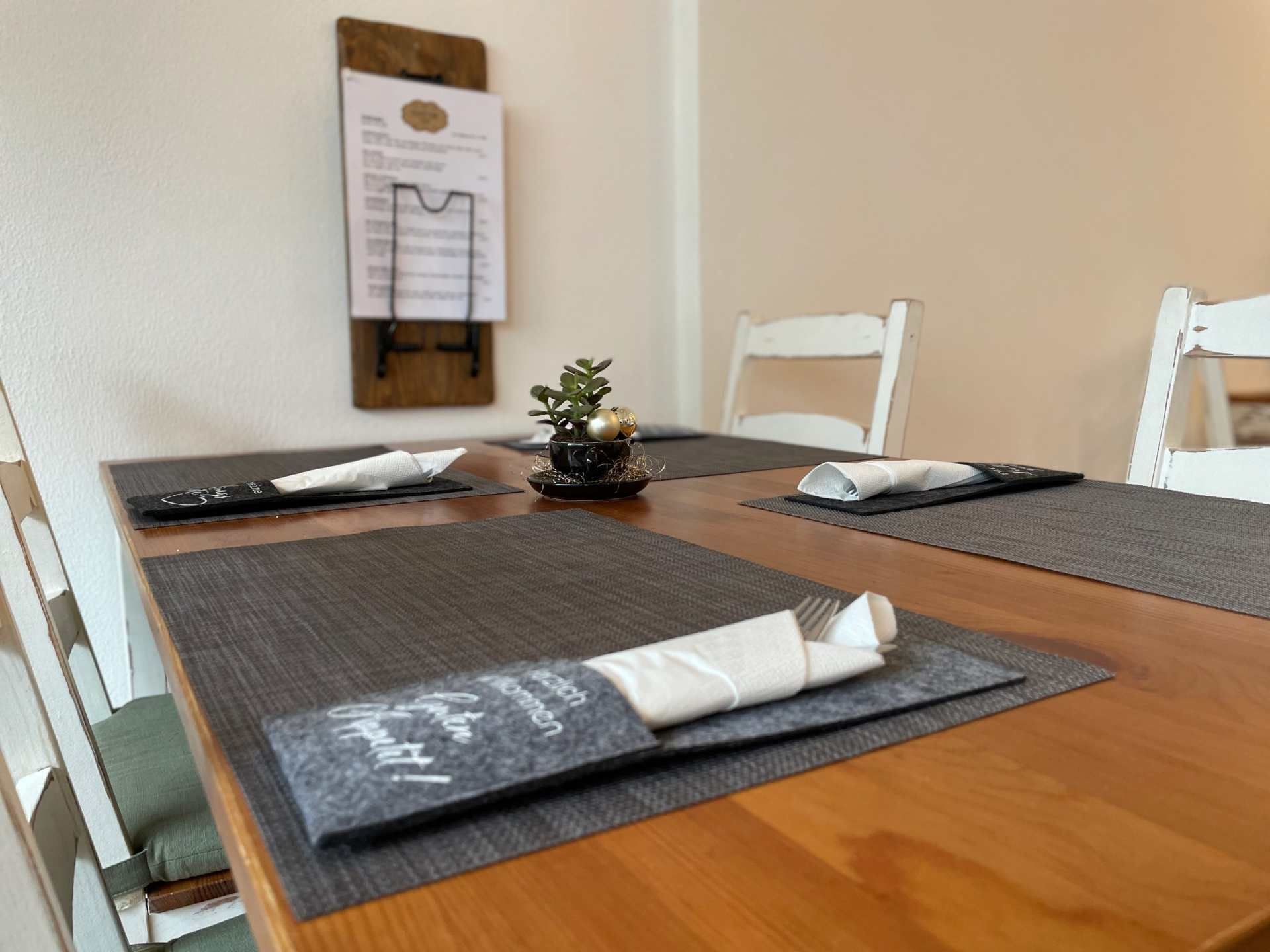 Ein Holztisch mit Tischsets und Servietten darauf, Mom & Son