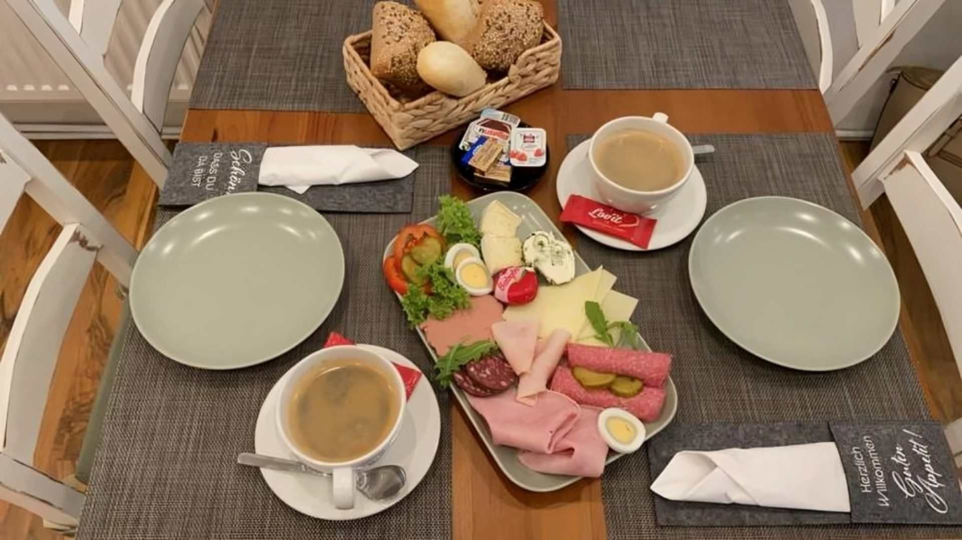 Ein Tisch mit Tellern und Tassen Kaffee und Essen darauf, Mom & Son