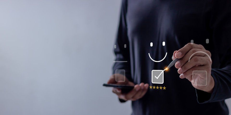 Eine Person hält ein Mobiltelefon und zeichnet ein Smiley darauf. Mom & Son