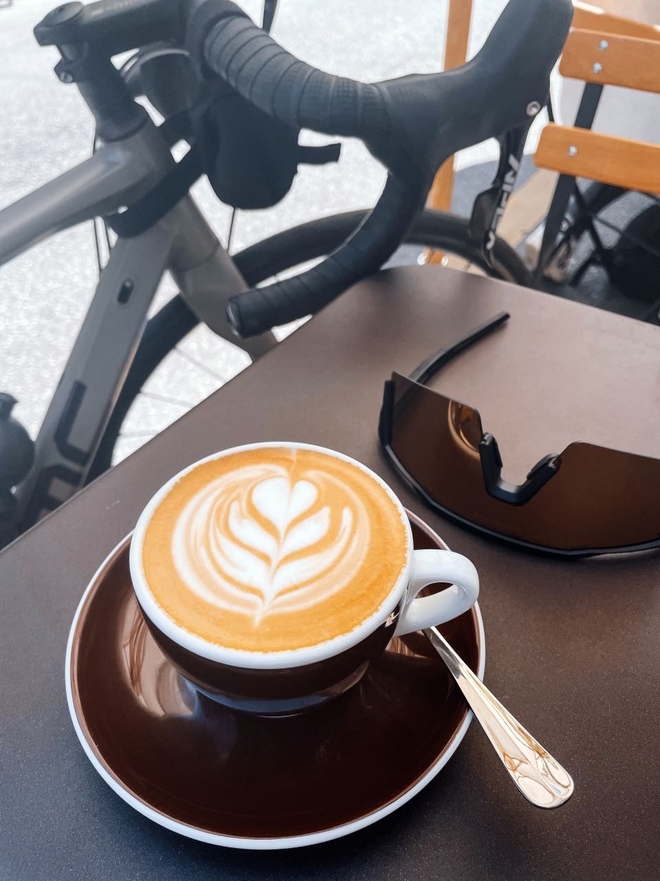 Eine Tasse Cappuccino auf einer Untertasse neben einem Fahrrad, Mom & Son
