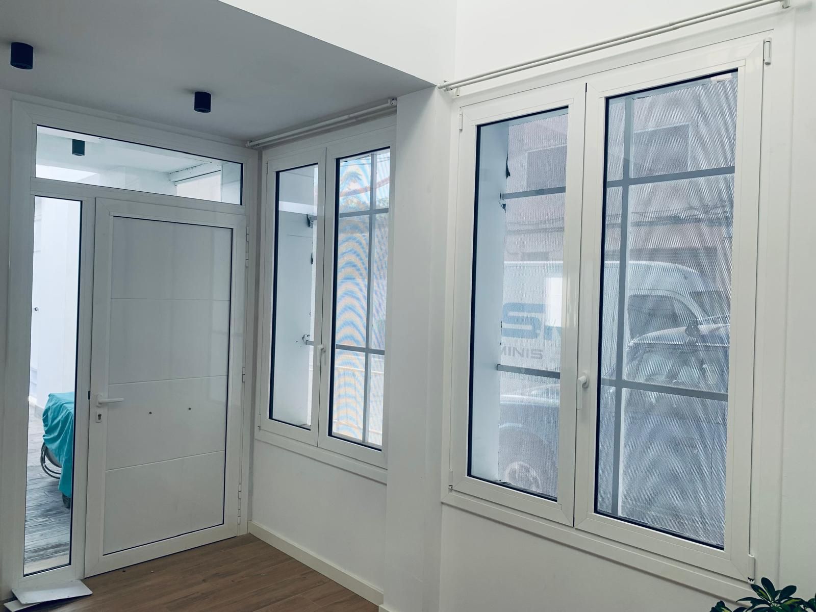 Interior blanco con ventanas y puerta. La luz entra a raudales.