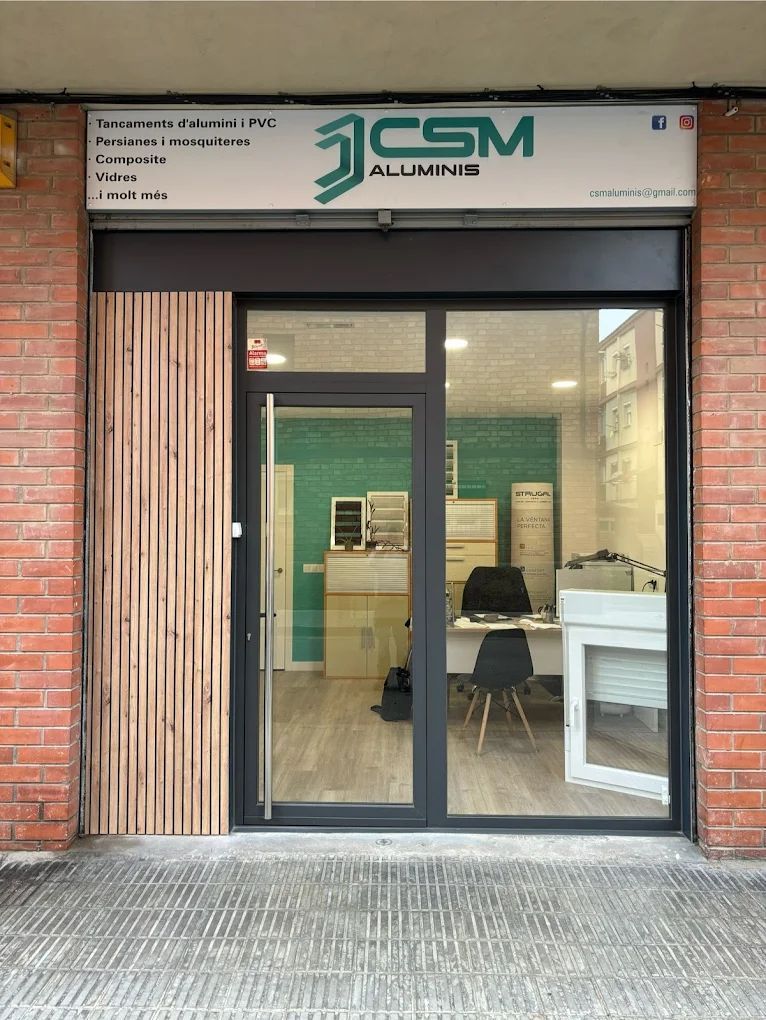 Exterior de una tienda de CSM Aluminios, con puerta de cristal, cartel de color verde azulado claro y panel lateral de madera.