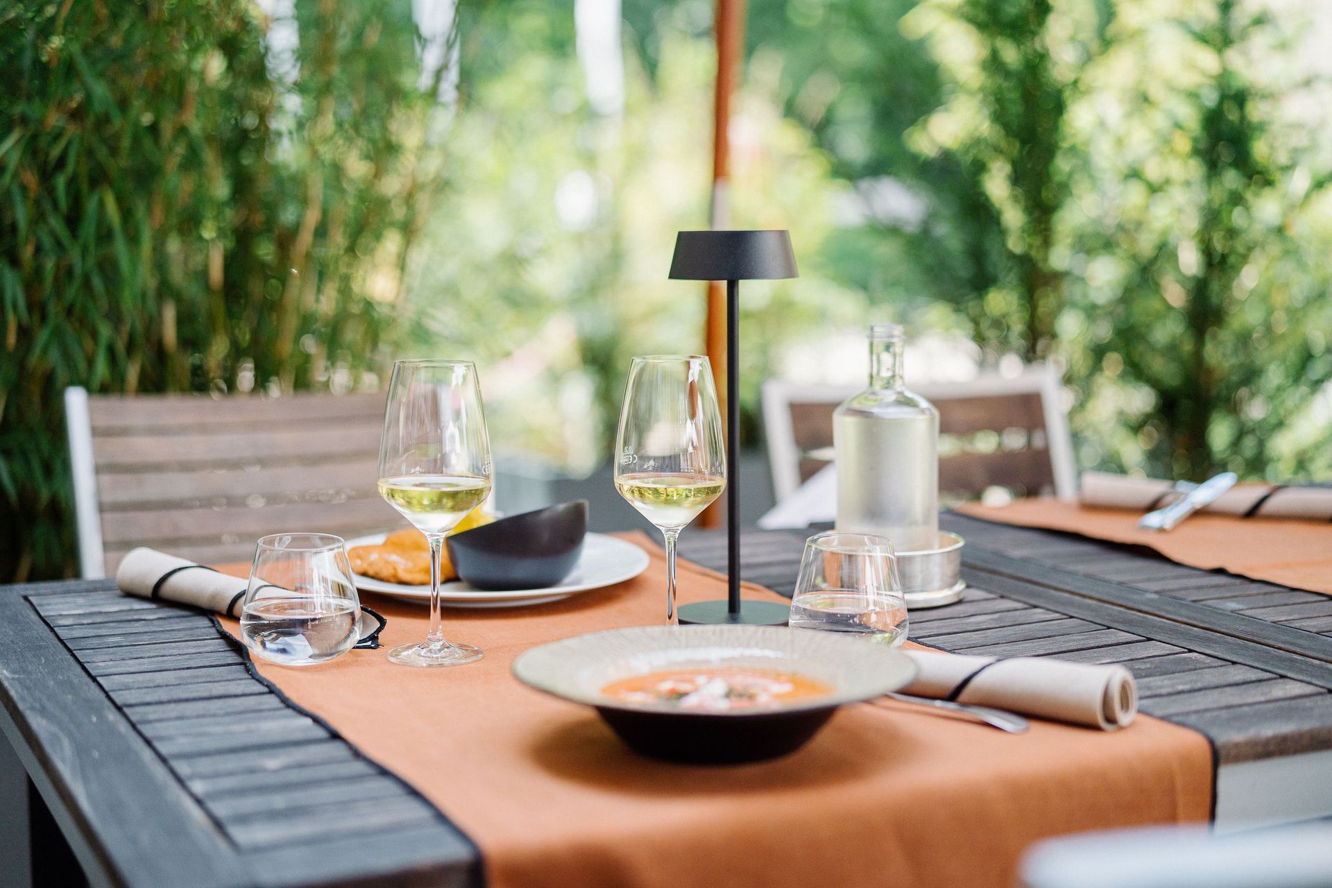 Ein gedeckter Tisch auf der Terrasse im bistro in der remise in Essen Kettwig mit Schnitzel und Wein