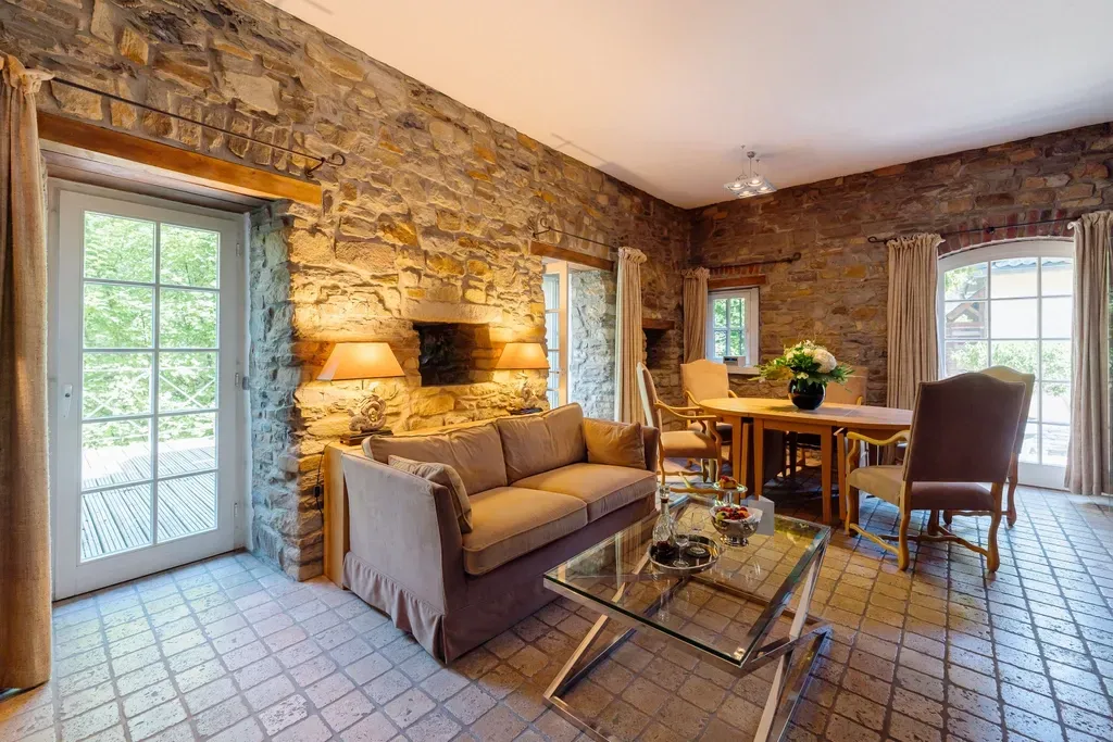Der komfortable Wohnraum im Hotelzimmer Villa Türmchen mit einem Sofa und einer Sitzgruppe im Schlosshotel Hugenpoet
