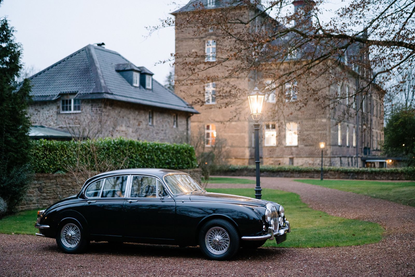 Vor einem großen Gebäude parkt ein schwarzes Auto.