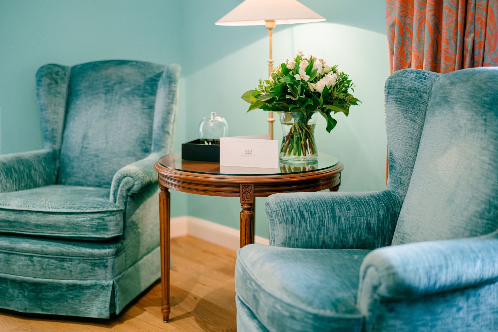 Eine gemütliche Sitzgruppe mit zwei türkisfarbenen Sesseln in einem Superior Doppelzimmer im Schlosshotel Hugenpoet
