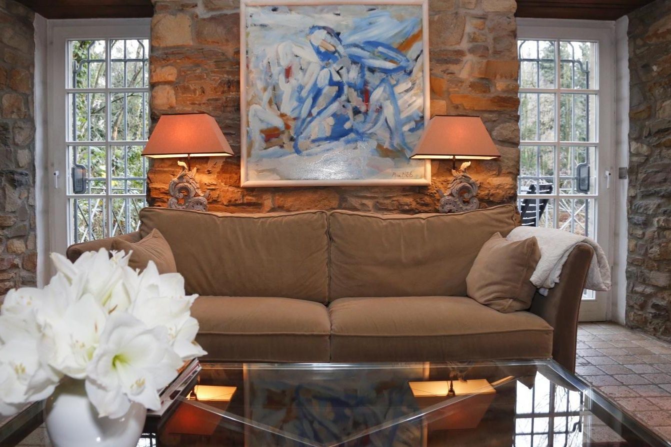 Nahaufnahme der Couch und eines Kunstwerks im Wohnbereich im Hotelzimmer Villa Türmchen im Schlosshotel Hugenpoet in Essen.