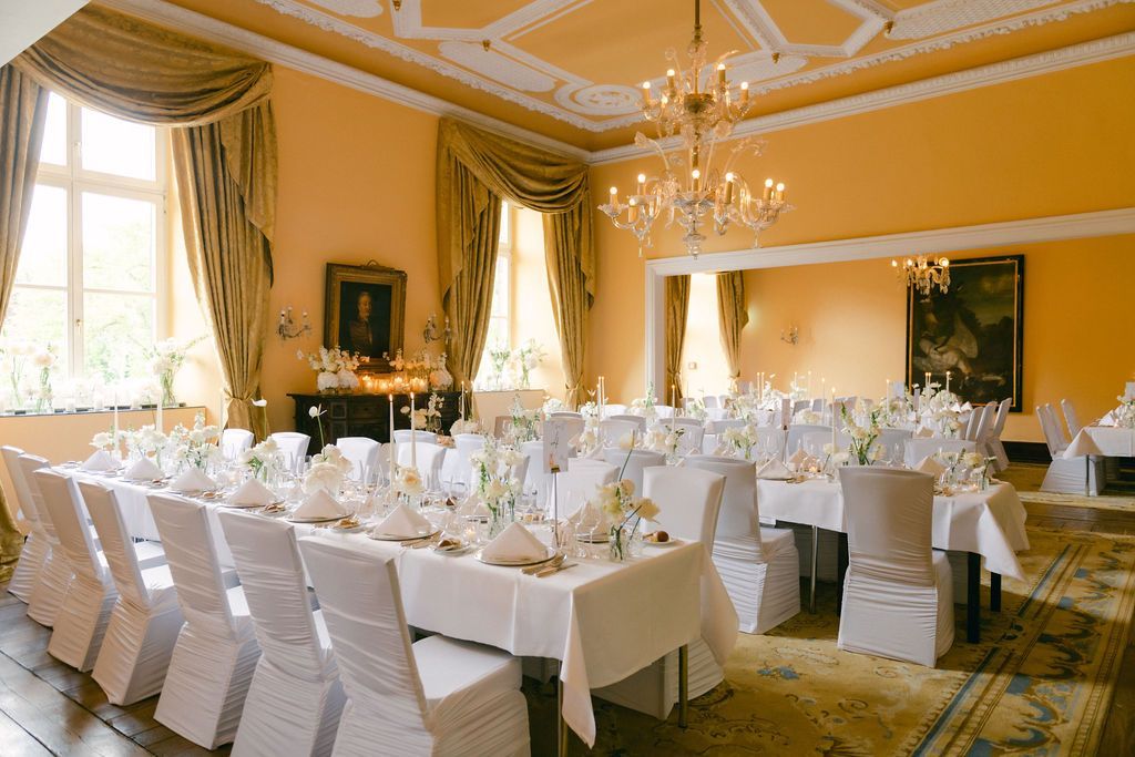 Der Festsaal im Schlosshotel Hugenpoet mit langen Tafeln für eine Veranstaltung oder Hochzeit.