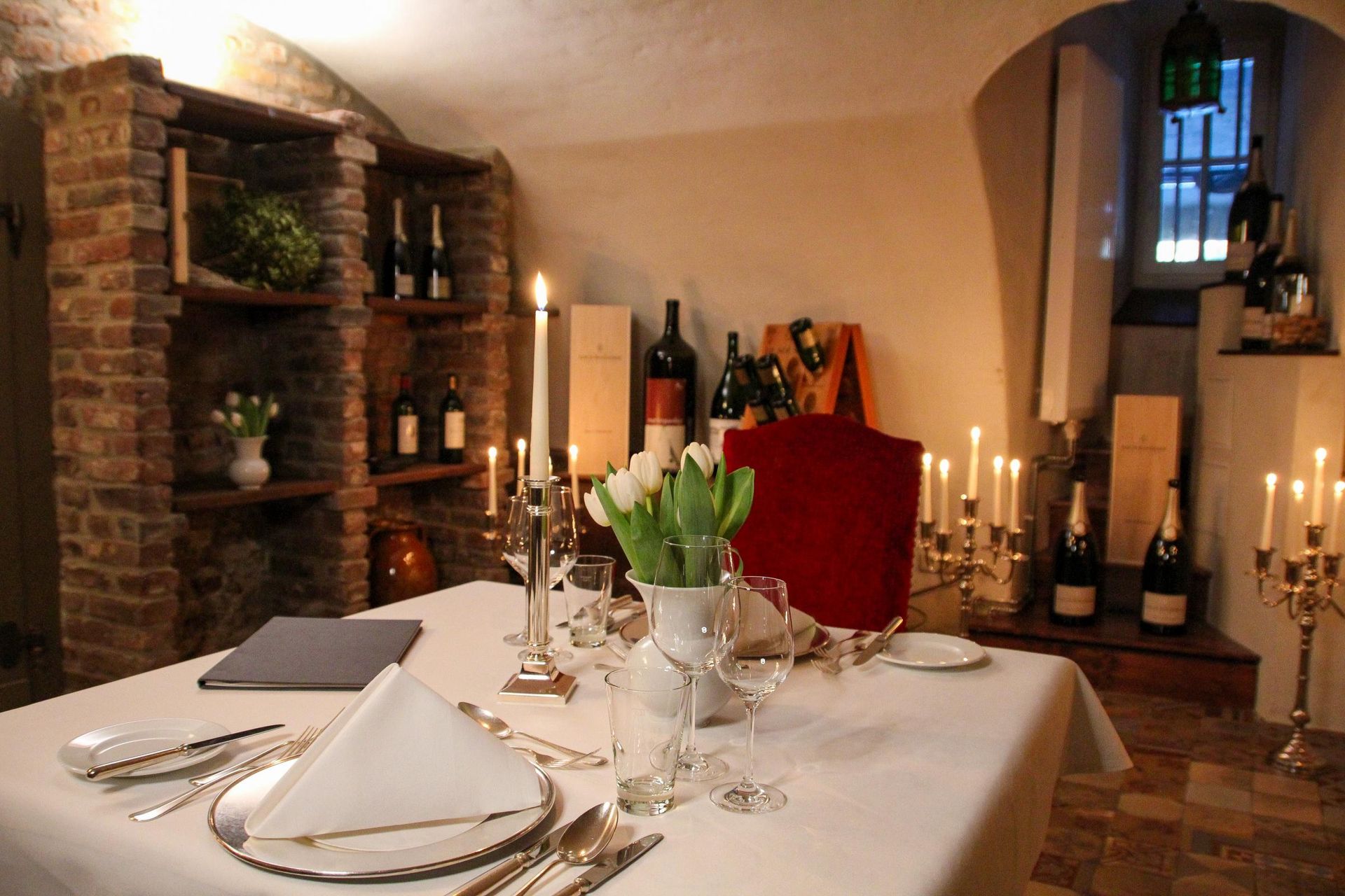 Romantisches Dinner zu Zweit mit einem eingedeckten Tisch bei Kerzenschein im Weinkeller im Schlosshotel Hugenpoet